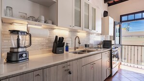 Una cocina moderna con batidora integrada, juego de cuchillos y microondas.