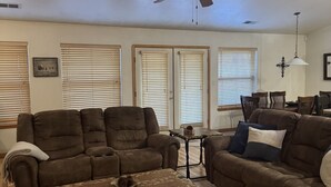 Ein Wohnzimmer mit zwei braunen Sofas, einem Couchtisch und einem Deckenventilator.