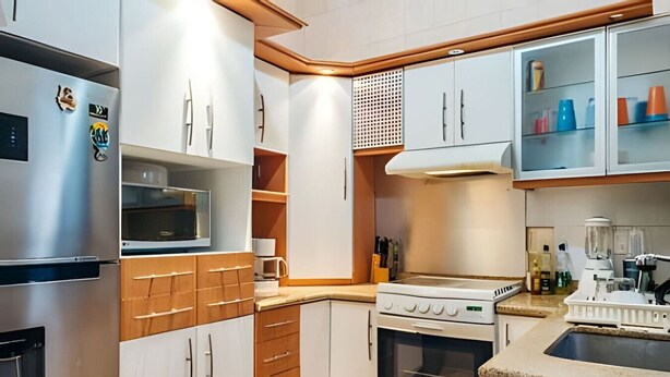 A compact kitchen with a refrigerator, microwave, oven, and a sink.