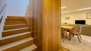 Un interior moderno con una escalera de madera que conduce a una sala de estar.