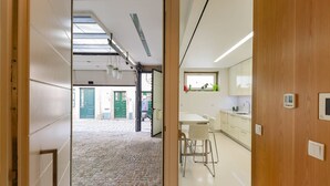 Cocina moderna con armarios blancos, un lavamanos y un ventanal.