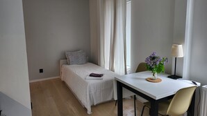 A small, neatly arranged bedroom with a single bed, a bedside table with a lamp, and a chair. - Apartment - Sleeps 3 & Great Location (Sollentuna)