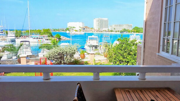 A balcony with a view of a marina, boats, and buildings.