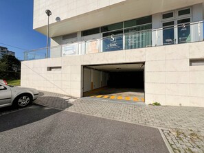 Un bâtiment moderne, avec une enseigne indiquant qu’il s’agit d’une clinique, une entrée abritée et une voiture garée devant.