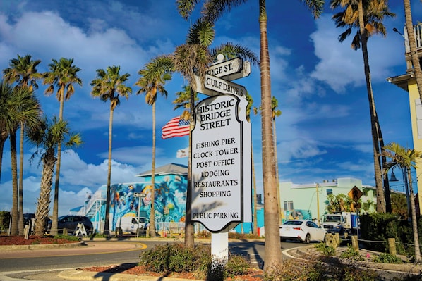 A street sign with directions to Gulf Drive S., Historic Bridge Street, and public parking.