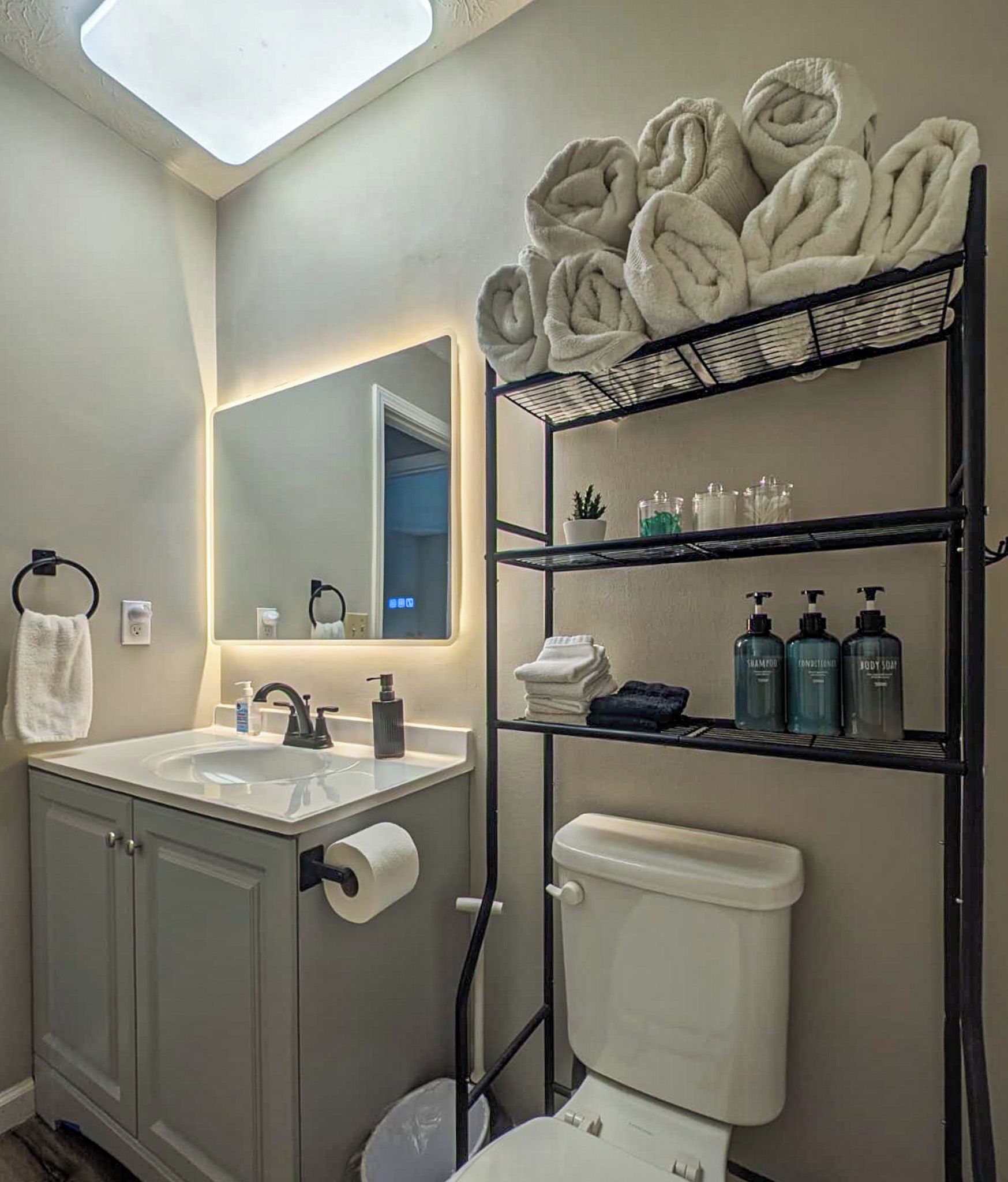 A modern bathroom with a toilet, sink, and a towel rack.