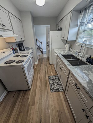 A kitchen with a stove, refrigerator, and sink. - Cozy & Charming 2-bedroom, 2 bath in Central location near Cincinnati (Erlanger)