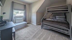 A room with a bunk bed, a desk with a chair, a window with curtains, and a ceiling fan. - Cozy & Charming 2-bedroom, 2 bath in Central location near Cincinnati (Erlanger)