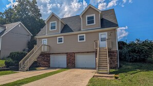 A two-story house with a front garage, a staircase, and a well-maintained lawn. - Cozy & Charming 2-bedroom, 2 bath in Central location near Cincinnati (Erlanger)