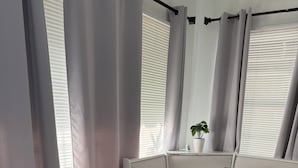 Ett modernt rum med ett bord med glasskiva, en bänk och en krukväxt.