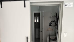 Een moderne keuken met een fornuis, een hangrek en een deur naar een gang.