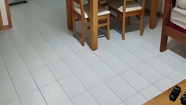 Ett kompakt kök med vita skåp, en mikrovågsugn och en kaffebryggare. Där finns också ett matbord i trä med fyra stolar.