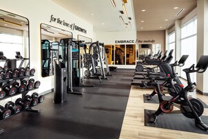 Un gimnasio con equipos de ejercicio variados, incluyendo cintas de correr y máquinas de pesas.