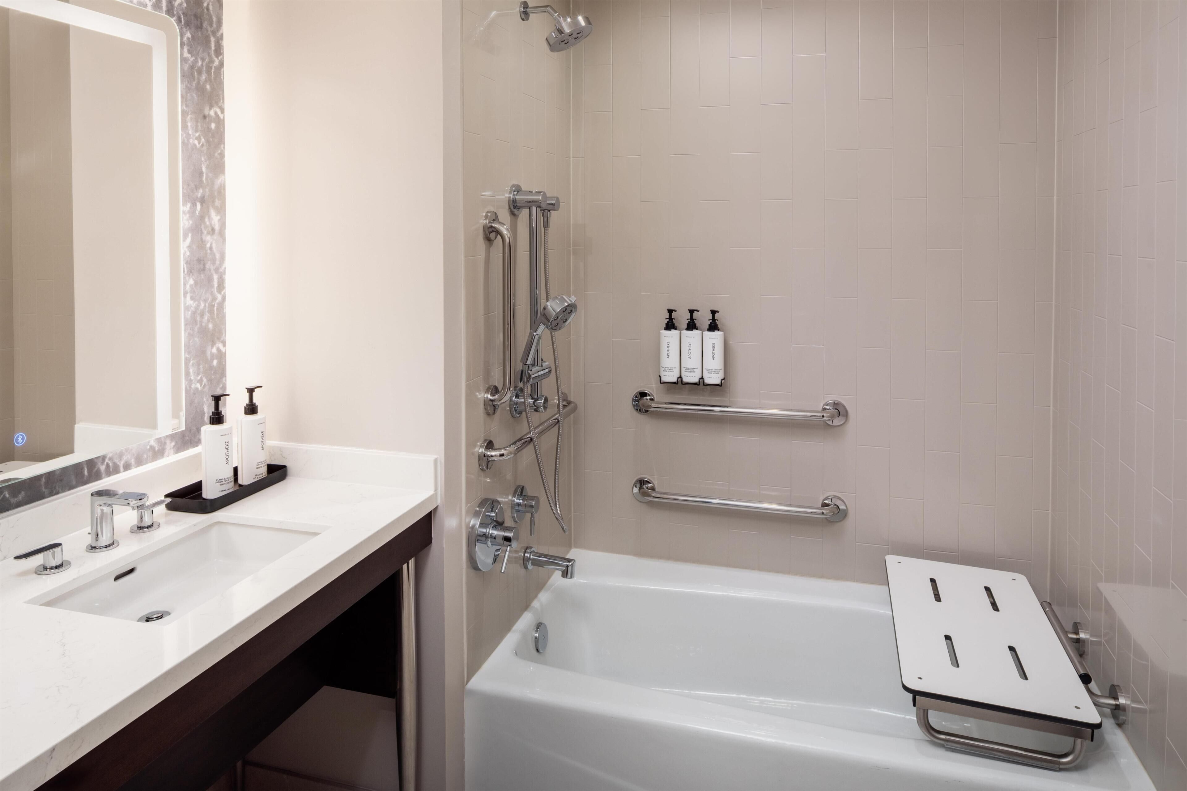 A modern bathroom with a bathtub, a sink, and a shower.