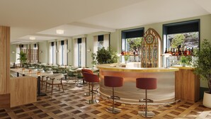 A modern bar area with a central bar, multiple seating options including bar stools and chairs, and a checkered wooden floor. - The Derby London City, Curio Collection By Hilton (London)