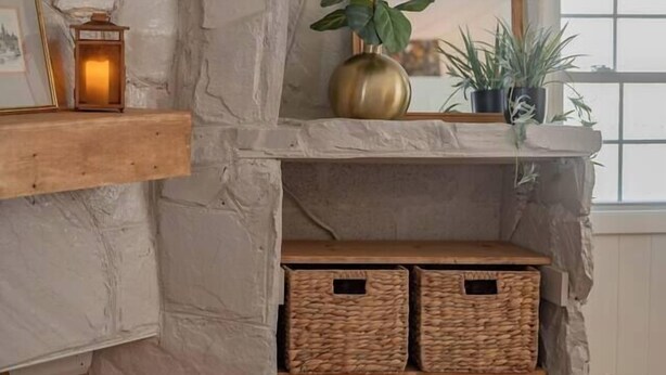 A stone fireplace with a mirror, wicker baskets, and a potted plant. - Cozy 3BR Home | KING Bed | ONLY 8-Min to LU! (Lynchburg)