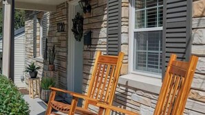 A stone house with a covered porch and two wooden rocking chairs. - Cozy 3BR Home | KING Bed | ONLY 8-Min to LU! (Lynchburg)