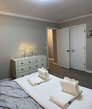 A bedroom with a bed, a dresser, and a wardrobe.