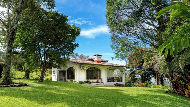 A house with a tiled roof, arched windows, and a well-maintained lawn.