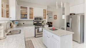 A modern kitchen with white cabinetry, a stainless steel refrigerator, a built-in oven, and a microwave. - Cozy Comfort/ 2-Bedroom Plainfield Getaway (Plainfield)