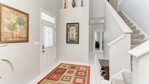 A hallway with a patterned rug, a door, and a staircase. - Cozy Comfort/ 2-Bedroom Plainfield Getaway (Plainfield)