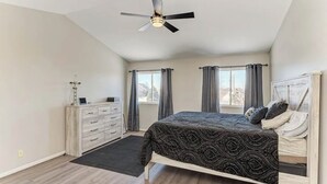 A bedroom with a bed, a dresser, a ceiling fan, and two windows with curtains. - Cozy Comfort/ 2-Bedroom Plainfield Getaway (Plainfield)