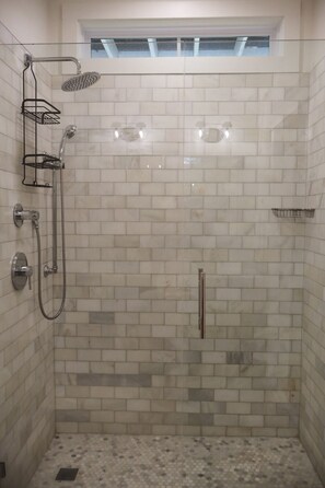 A shower with a glass door, a metal showerhead, and a handheld showerhead. - 121 Allison Way townhouse (Algood)