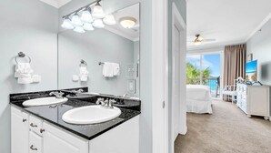 Une salle de bain moderne avec deux vasques, un grand miroir et un ventilateur de plafond.