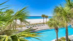 Un espace piscine offrant une vue sur la plage et l’océan.