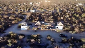 An aerial view of a desert resort with multiple buildings, a swimming pool, and a car parked in front. - Baja Desconocida Ranch Seaview (El Sargento)
