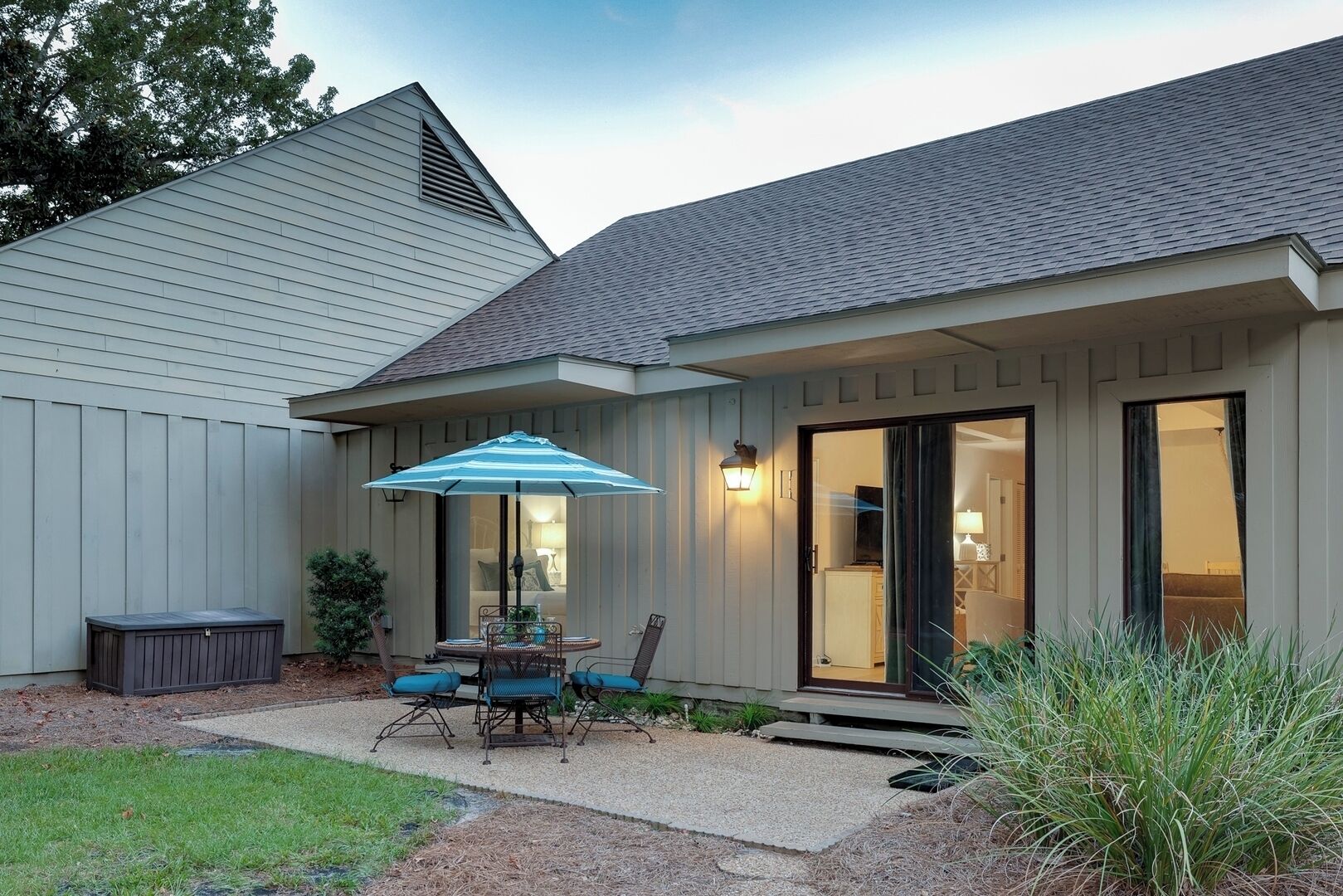 Une maison avec un patio, un espace extérieur aménagé et couvert, et un garage.