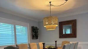 A dining room with a wooden table, six upholstered chairs, a hanging chandelier, and a large mirror on the wall. - Gisella‘s Beach House II
Five minute drive to the beach (Vero Beach)
