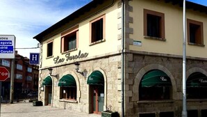 A building with the name "Las Farolas" on the facade, featuring arched windows and a stone exterior. - Hotel Rural Las Farolas (El Espinar)