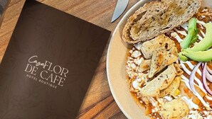 A table with a plate of food, a cup of coffee, and a menu from Casa Flor De Cafe. - Hotel Boutique Casa Flor de Café (Mexico City)