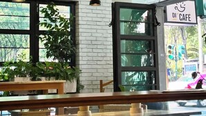 A cafe interior with white brick walls, pendant lighting, and a view of the street outside. - Hotel Boutique Casa Flor de Café (Mexico City)