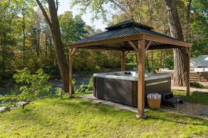 A hot tub under a wooden gazebo in a wooded area with a river in the background. - Amaya Bed&Breakfast (Oak Hill)