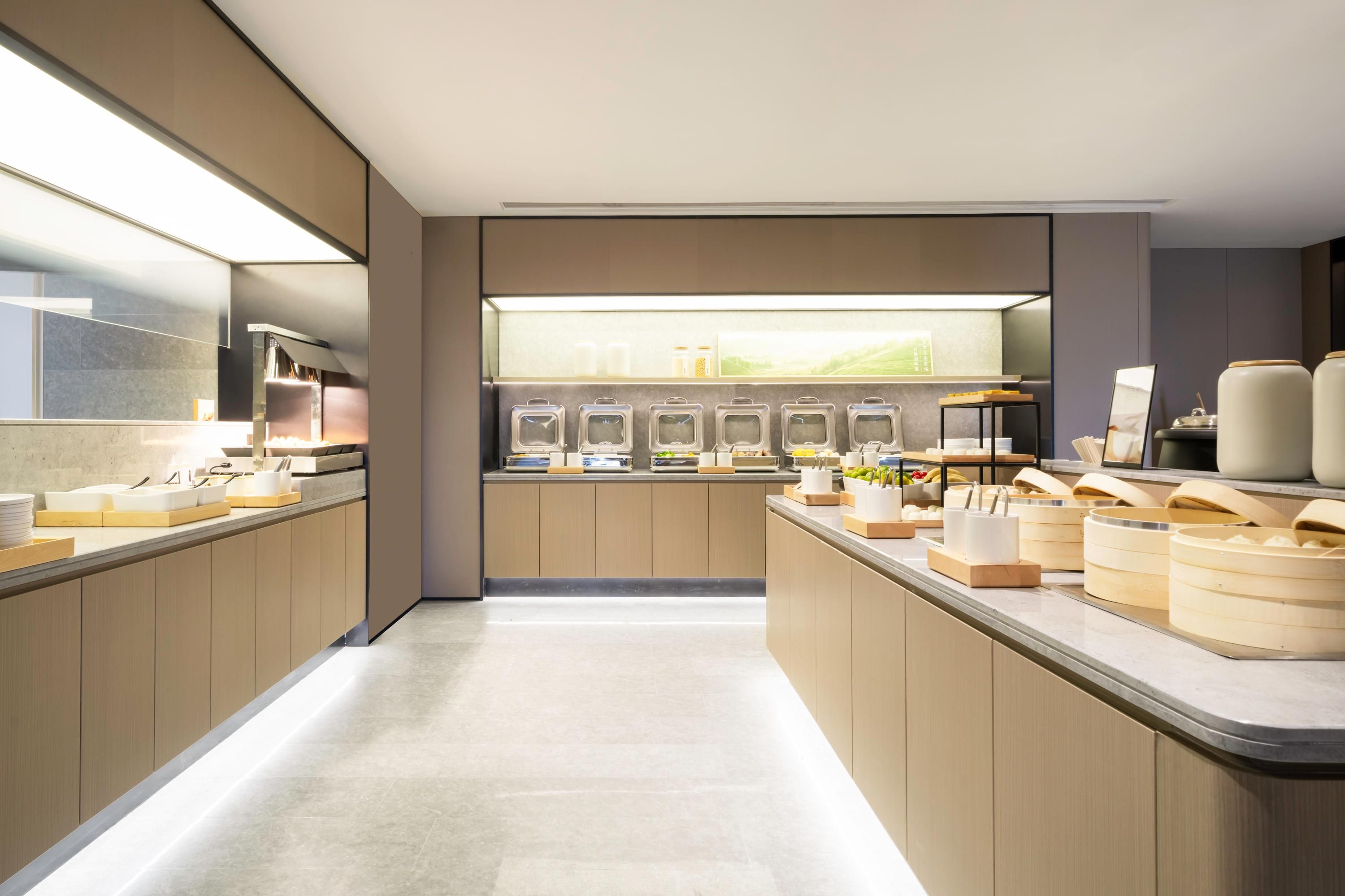 Una cocina moderna con una encimera larga, electrodomésticos integrados y vistas al exterior.
