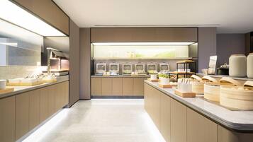 Una cocina moderna con una encimera larga, electrodomésticos integrados y vistas al exterior.