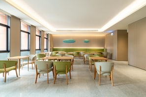 Une salle de conférence moderne et bien éclairée, avec des tables et des chaises disposées pour les réunions.