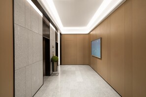 A modern hallway with a marble floor, a potted plant, and a framed picture on the wall. - Ji Hotel Guangzhou North Railway Station (Guangzhou)