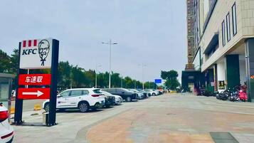 Un estacionamiento con autos y el letrero de KFC.
