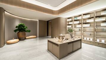 A modern interior with a central island, bookshelves, and a large potted plant.