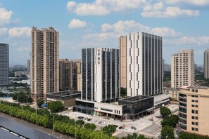 A modern hotel with a central tower and a smaller building with a glass facade. - Ji Hotel Guangzhou North Railway Station (Guangzhou)