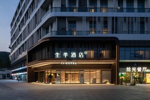 A hotel with a modern facade, large glass windows, and a prominent entrance.