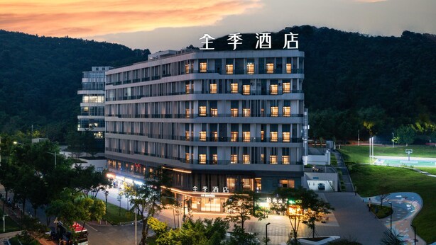 A multi-story hotel with a modern design, featuring a central courtyard and a view of the surrounding landscape. - Ji Hotel Guangzhou Tianhe Smart City Wetland Park (Guangzhou)