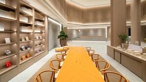 Une salle de conférence moderne, dotée d’une longue table, de chaises et d’étagères.