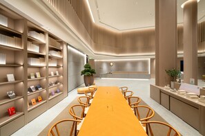 A modern conference room with a long table, chairs, and bookshelves. - Ji Hotel Guangzhou Sun Yat-sen University Metro (Guangzhou)