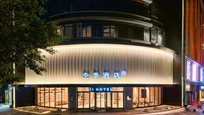 A hotel with a modern design, featuring a prominent entrance and a sign with Chinese characters. - Ji Hotel Guangzhou Sun Yat-sen University Metro (Guangzhou)