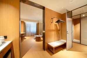 A modern hotel room with a wooden floor, a bench, a small table, and a sliding door leading to another room. - Ji Hotel Guangzhou Sun Yat-sen University Metro (Guangzhou)
