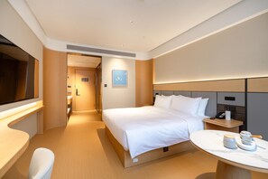 A modern hotel room with a large bed, bedside table, and a small round table with a lamp. - Ji Hotel Guangzhou Sun Yat-sen University Metro (Guangzhou)